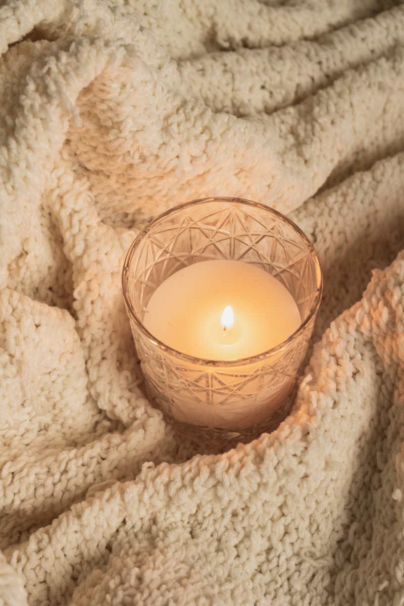 Lighted Candle on Wool Blanket